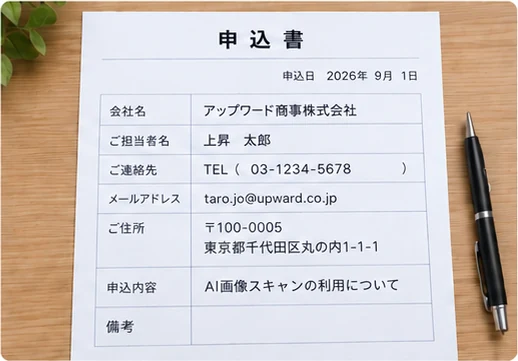 手書きで記入された申込書を机の上に置き、スマートフォンで撮影している写真